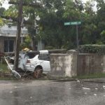Car smashes into wall, brings down two poles