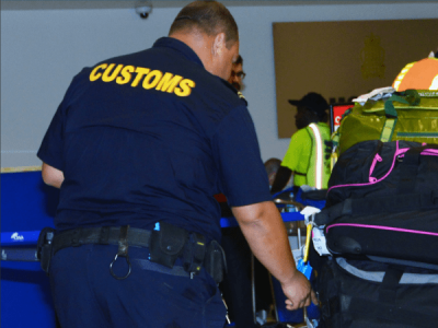 Audit Was At Challenging Time Says Customs Cayman News Service   Cayman Islands Customs Officer Exanmines Bags  400x300 